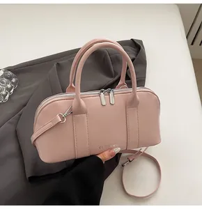 Detalle del bolso Boston de piel sintética rosa claro con logo CLEAR♥K y asa ajustable