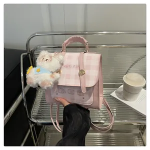 Pink checkered backpack with white plush puppy charm and cute cartoon bear print detail
