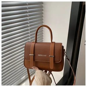 Détail du sac boîte marron avec rabat texturé et texte Fashion & Bags imprimé dessus