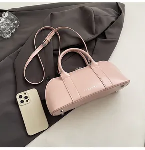 Detalle de bolso Boston rosa con marca CLEAR K y correa de hombro ajustable cómoda