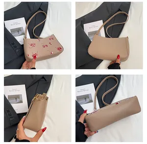 Detaillierte Ansicht mit Kirschprint und Textur der beigefarbenen PU-Ledertasche