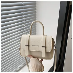 Gros plan du sac boîte crème montrant le mélange de cuir lisse et de cuir grainé