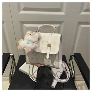 Detail of beige checkered handbag with bear print, plush charm and golden turn-lock