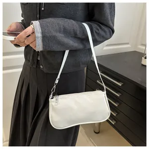 White patent leather baguette bag shown on shoulder with silver zipper and sleek finish