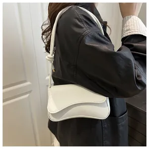 Model met witte okseltas met unieke golvende klep en decoratief knoopdetail op de riem