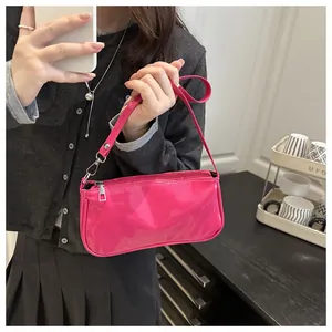 Detailed view of the glossy hot pink patent leather finish on a chic baguette bag