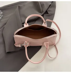 Vista interior del bolso satchel de cuero rosa mate con un espacioso forro de tela marrón