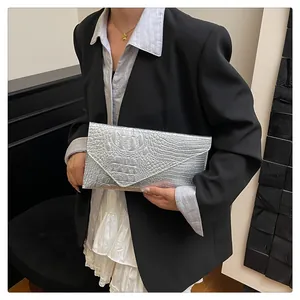 Detailed view of silver envelope clutch bag with textured crocodile skin pattern