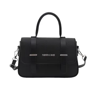 Sac à main boîte noir minimaliste avec fermeture à rabat et détails en cuir texturé