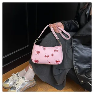Rosa Schultertasche mit Kirschmuster und verstellbarem Riemen an einem Modell