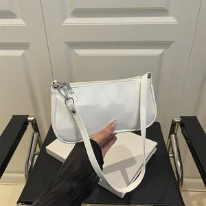 Chic white patent leather baguette bag with silver hardware and shoulder strap