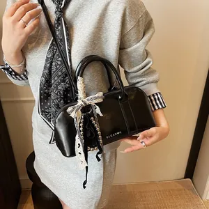 Bolso Boston negro con lazos y perlas mostrado en una toma de estilo de vida moderna