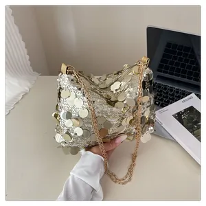 Dettaglio delle paillettes oro e argento scintillanti e della tracolla a catena d'oro