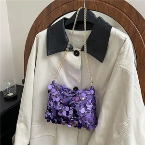 Borsa a mano viola con paillettes e tracolla a catena dorata per look da festa