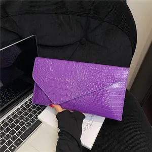 Glossy purple crocodile pattern envelope clutch bag held for daily or evening use