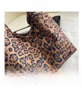 Nahaufnahme von Samtstoff mit Leopardenmuster zeigt die weiche Textur der Tasche