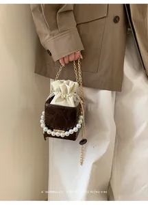Dettaglio della borsa con motivo a serpente con perle eleganti e catena dorata