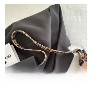 Detail eines breiten Schultergurts mit Leopardenmuster für eine Damen-Handtasche