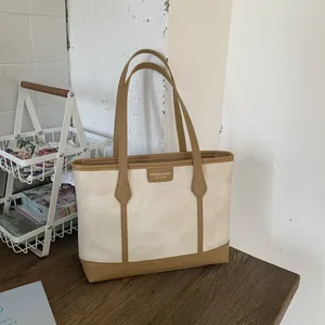 Minimalist beige matte tote bag with brown leather handles for stylish daily commute