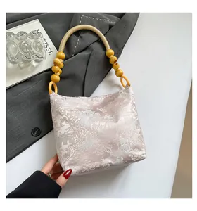 Dettaglio ravvicinato della borsa tote neo-cinese con ricami artistici e grandi perle in legno