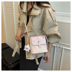 Detail view of mini pink bucket bag featuring cartoon cat print and heart buckle