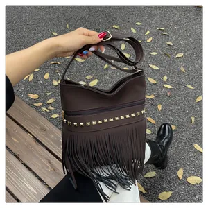 Détail du sac bandoulière marron foncé en daim avec clous dorés et longues franges