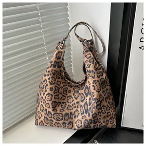 Detailansicht der Schultertasche mit Leopardenmuster und Metallösen am Trageriemen