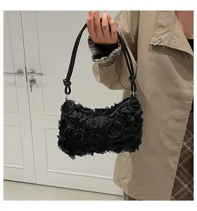 Close-up of black 3D lace flower handbag details with shoulder strap on a model