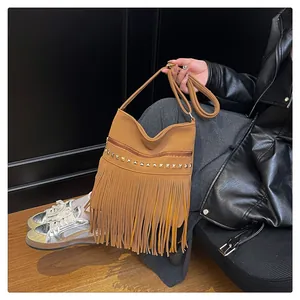 Détail du sac en daim marron avec franges et clous métalliques de style bohème