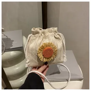 Detail van beige geweven emmertas met zonnebloem en witte katoenen schouderband