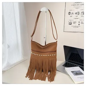 Détail du sac bandoulière en daim marron avec clous dorés et longues franges bohèmes