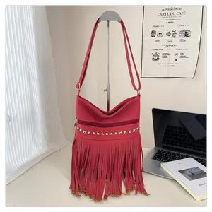 Détail du sac en daim rose fuchsia avec clous dorés et élégantes longues franges