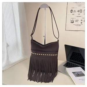 Détail du sac bandoulière vintage marron avec clous carrés dorés et longues franges