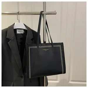 Bolso tote de cuero negro con remaches dorados y correas dobles para mujeres profesionales