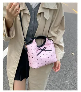Vue détaillée du sac à bandoulière rose plissé avec imprimés et détails de nœuds