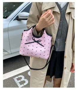 Détail du sac cabas rose avec nœuds noirs et bandoulière réglable en cuir véritable
