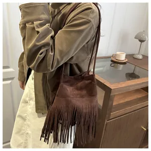 Gros plan d'un sac bandoulière vintage en daim marron avec détails de franges stylés