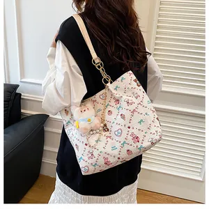 Detail of printed tote bag with metal chain strap and cute rabbit plush pendant accessory