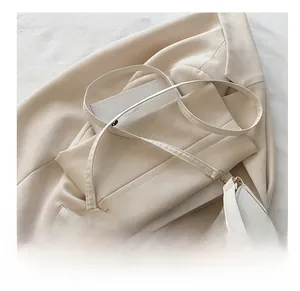 Detail of comfortable white leather strap and gold buckle on a stylish crossbody bag
