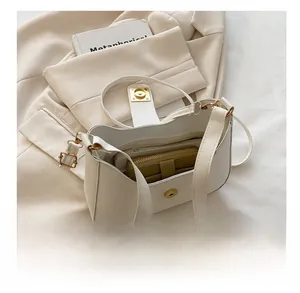 Top view of cream leather shoulder bag showing spacious interior with phone and wallet