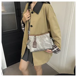 Detail of vintage grey bucket bag with brown leather trim and fashion tag on trench coat