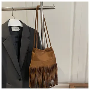 Détail du sac à bandoulière en daim marron avec de longues franges et fines anses
