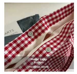 Close-up of red checkered canvas tote with magnetic metal buckle and fabric lining