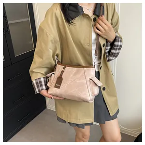 Detail of light pink vintage textured bucket bag with brown trim and side pockets