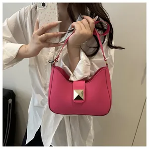 Détail du sac demi-lune en cuir fuchsia avec rivet doré et fine bandoulière