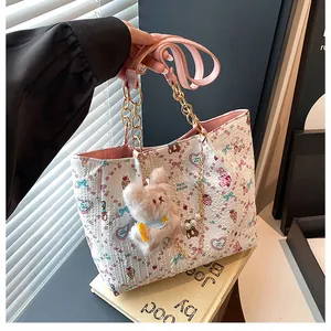 Detail of white tote bag with cute animal prints, pink lining and plush rabbit charm