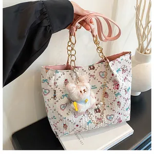 Detail of white canvas tote with cartoon bear prints and pink leather chain strap