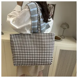 Close-up of a black and white gingham canvas tote bag with a spacious interior design