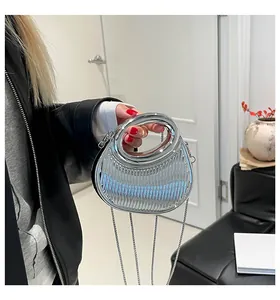 Gros plan sur un sac de soirée argenté avec poignée ronde et texture à rayures verticales