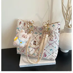 Detailed view of white cartoon tote bag with pearl chain handle and plush bear charm